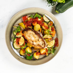 Gegrilde kip met Zuiderse tomatensaus, ovenaardappel, paprika & courgette